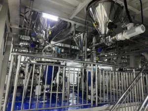 Vacuum-conveying automated powder feeding system for dust-free pigment loading in ink manufacturing.